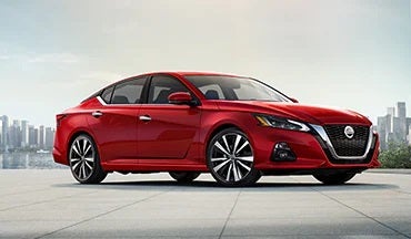 2023 Nissan Altima in red with city in background illustrating last year's 2022 model in Nissan City of Red Bank in Red Bank NJ